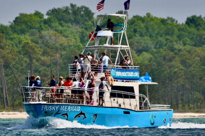 Frisky Mermaid dolphin cruise boat carrying guests on a sunny day in Pensacola Bay near Pensacola Beach, Florida