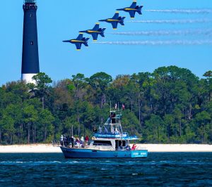 4 Blue Angels fly over Frisky Mermaid which is in front of the Pensacola Lighthouse for Blues Practice.