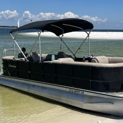 Pontoon boat rental beached near Gulf Islands National Seashore on a bright day.