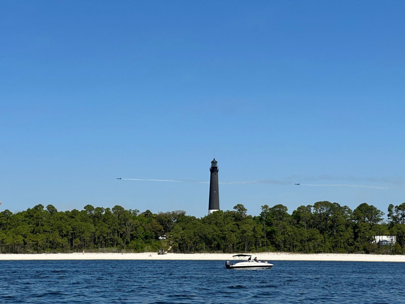 A view from the water of the Pensacola Lighthouse located near Fort Pickens in the distance.