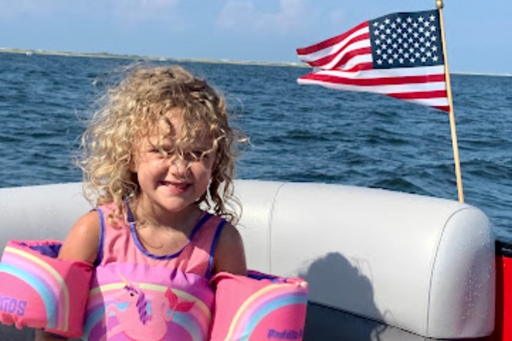 a little girl sitting on a pontoon boat rental from Frisky Boat Tours