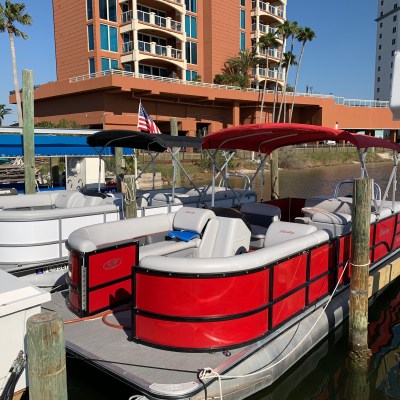Red Bentley pontoon docked at a marina waiting to be rented