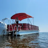 Red Bentley pontoon boat anchored off of Sand Island near Ft. McCrae.