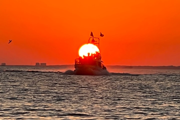 A beautiful Pensacola Beach sunset behind Frisky Mermaid Dolphin Boat.