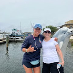 Two people together aboard a Frisky Mermaid dolphin tour boat while cruising the scenic waters of Pensacola Bay