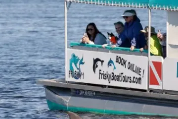 a group of people riding on the back of a boat in the water