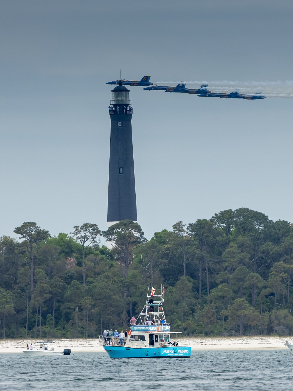 Blue Angels flying in formation over Pensacola Lighthouse during a Blue Angels Practice + Dolphin Tour with Frisky Mermaid Dolphin Cruises & Pontoon Boat Rentals on Santa Rosa Sound