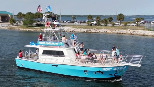 The Frisky Mermaid tour boat cruises through Pensacola Bay with guests enjoying a guided dolphin cruise from Frisky Mermaid Dolphin Cruises & Pontoon Boat Rentals