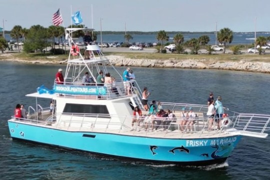 The Frisky Mermaid tour boat cruises through Pensacola Bay with guests enjoying a guided dolphin cruise from Frisky Mermaid Dolphin Cruises & Pontoon Boat Rentals