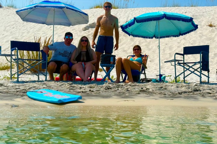 Group relaxing on a quiet sandbar beach near Pensacola Beach during a private boat tour.